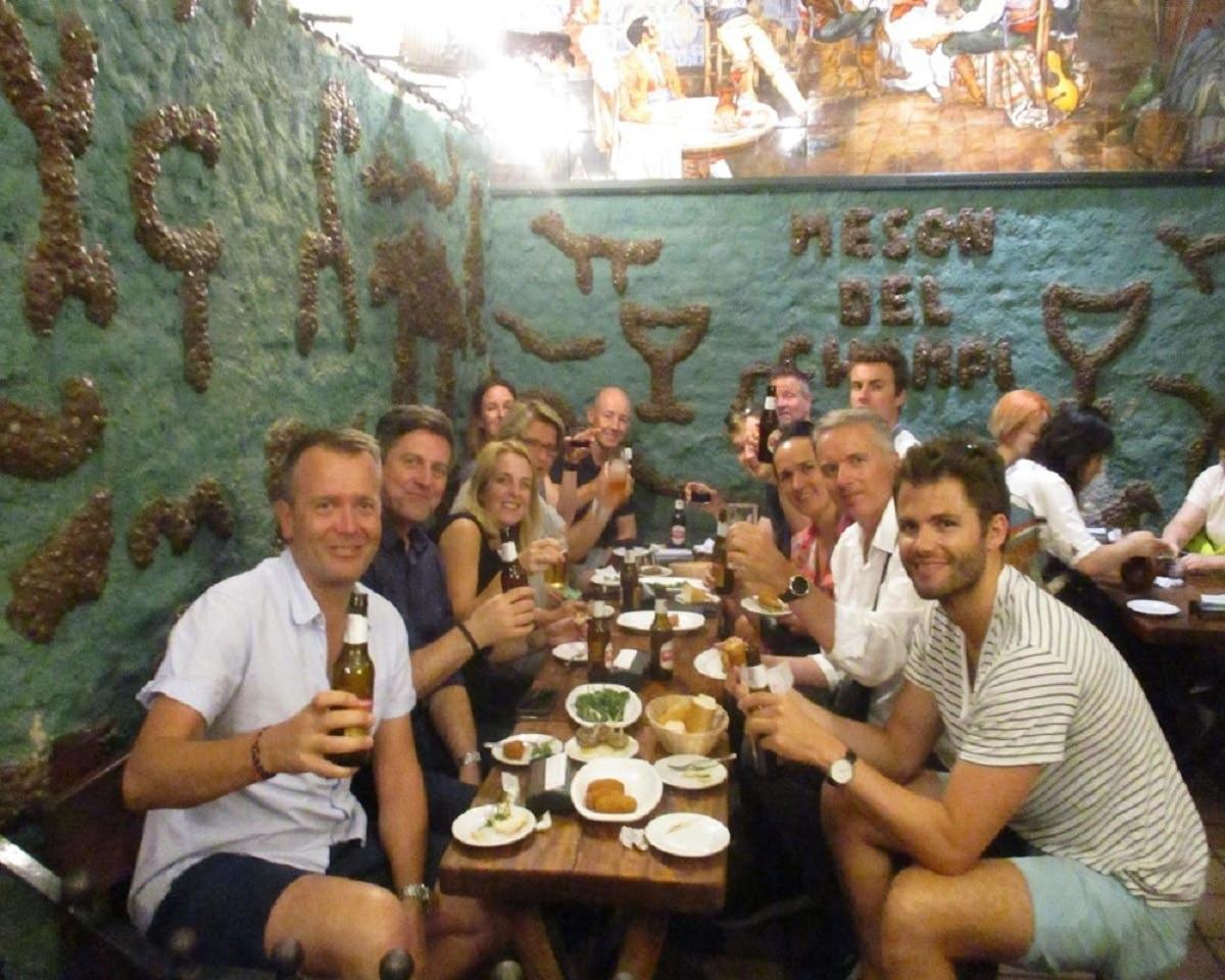 um grupo de pessoas sentadas ao redor de uma mesa em um restaurante
