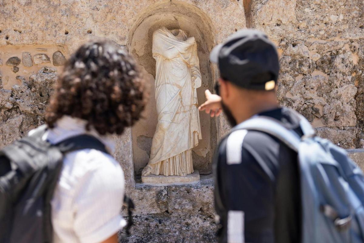 Δύο άνθρωποι κοιτάζουν ένα άγαλμα