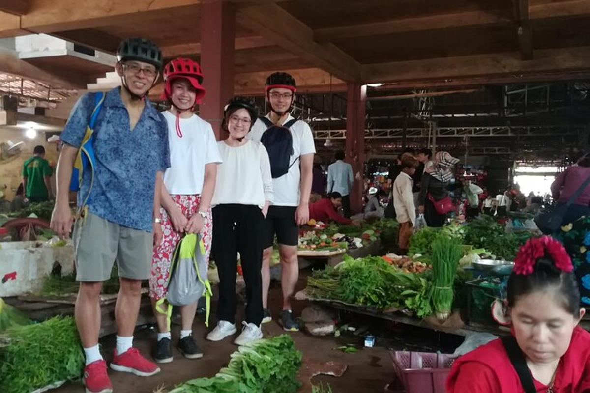 un gruppo di persone in piedi in un mercato con le verdure