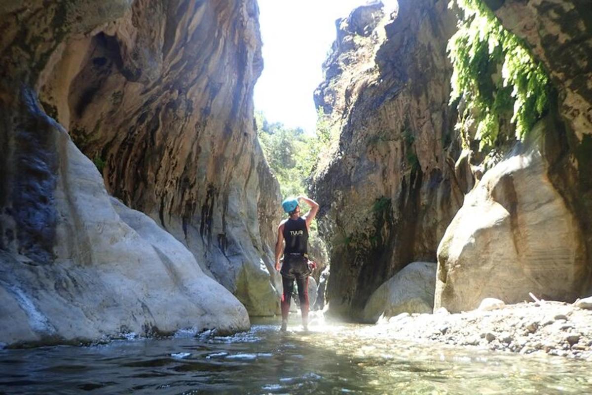 a man standing in the water in a canyon