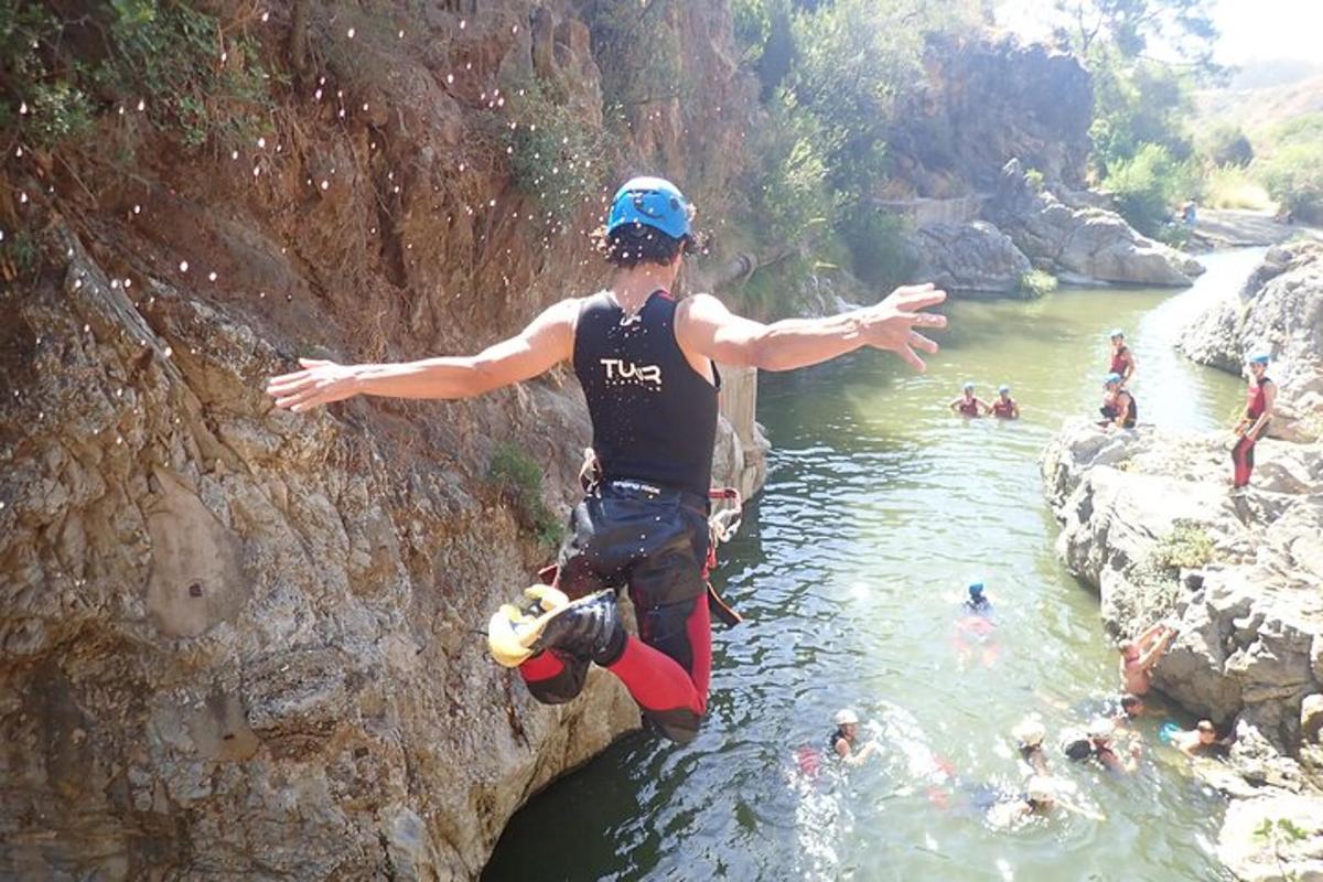 un uomo che salta da una scogliera in un fiume
