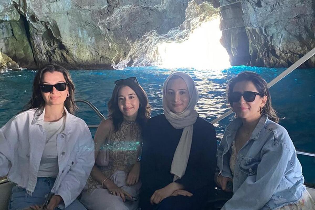 un groupe de femmes assises sur un bateau dans une grotte