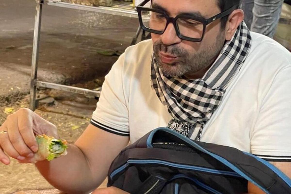 un uomo con gli occhiali che mangia un pezzo di cibo