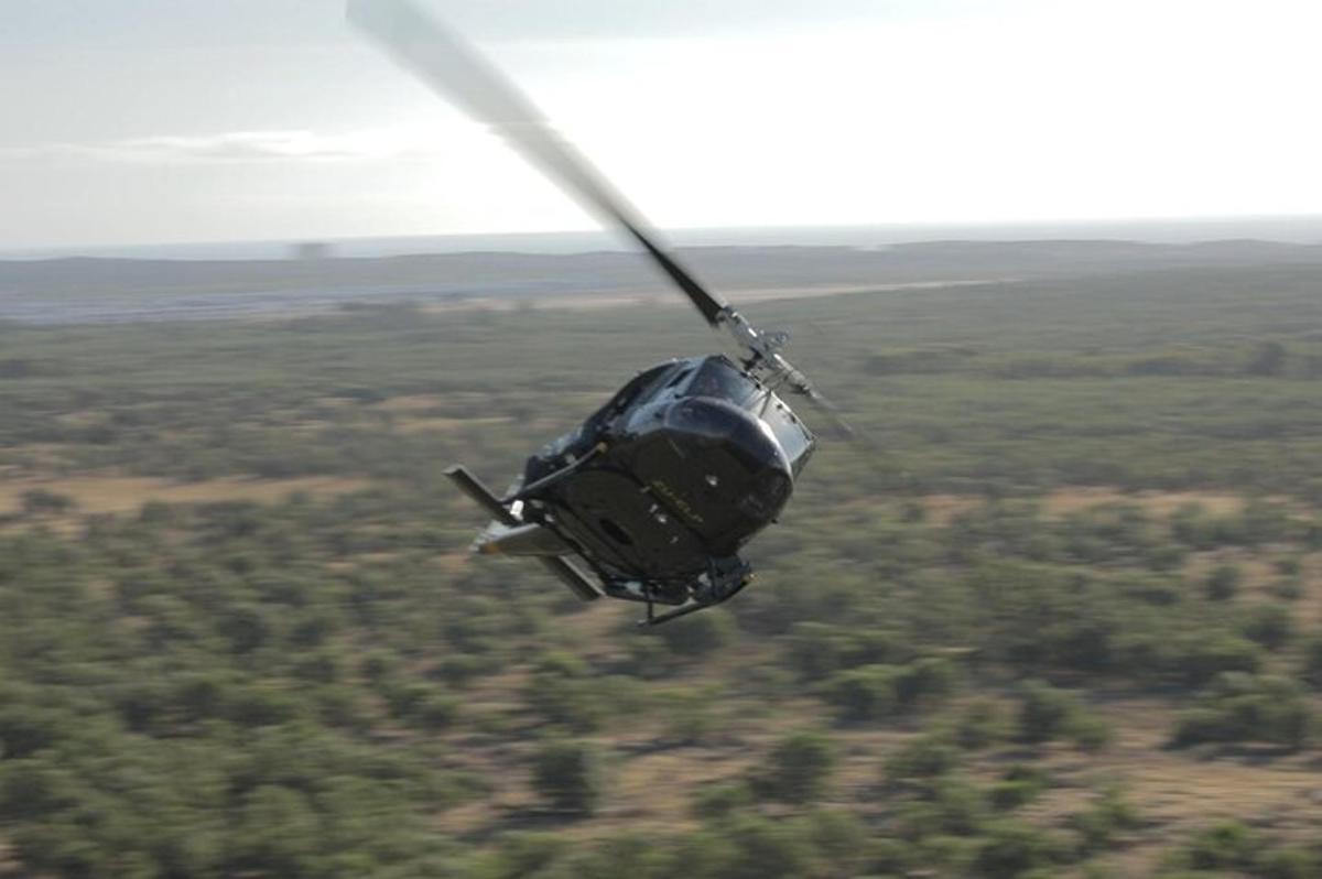 sebuah helikopter terbang di langit di atas padang