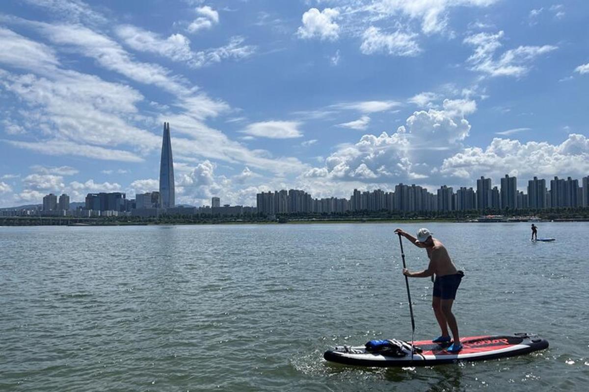 un home està dret sobre una taula de paddle surf a l'aigua
