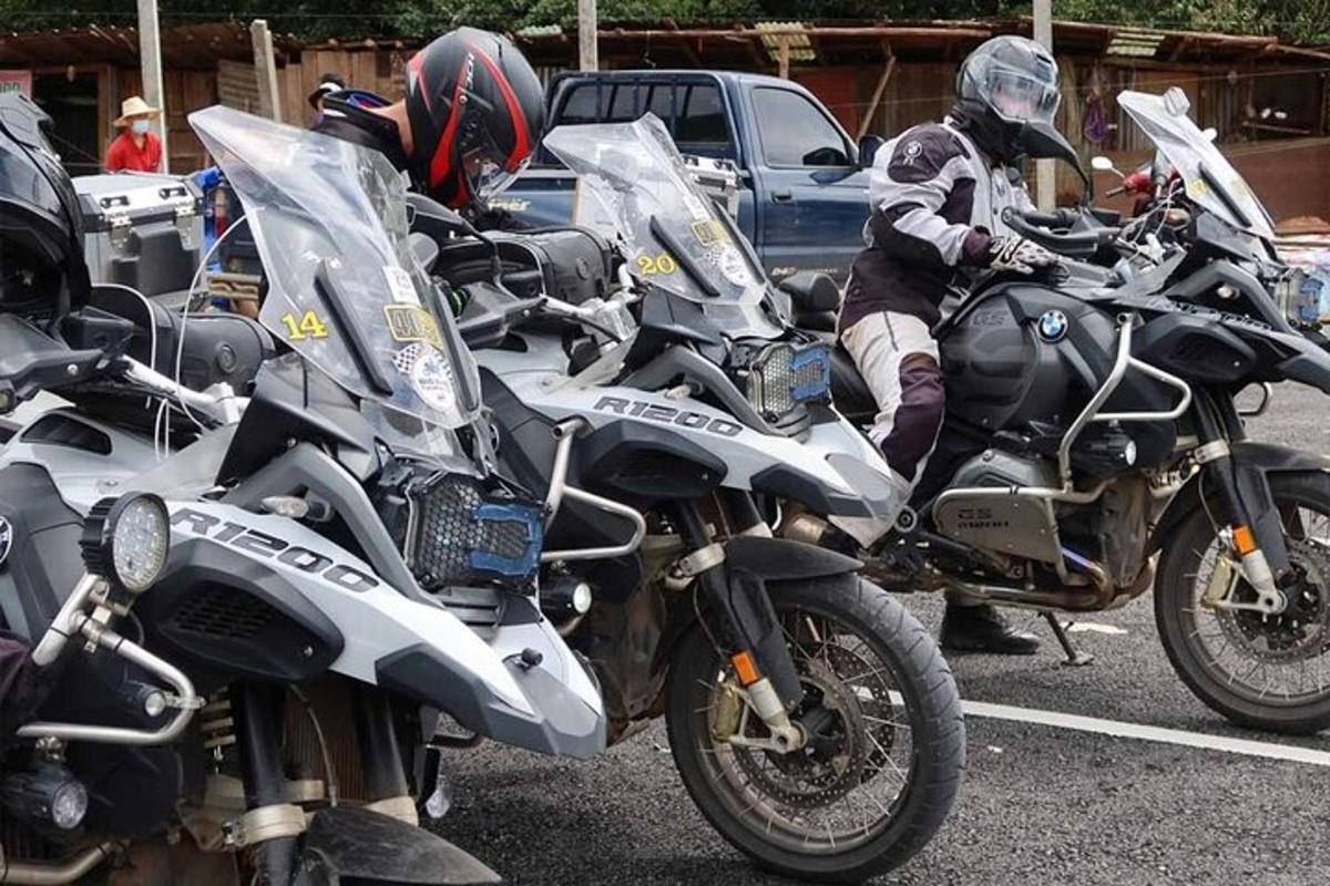 dvaja ľudia s prilbami sediaci na motorkách na parkovisku
