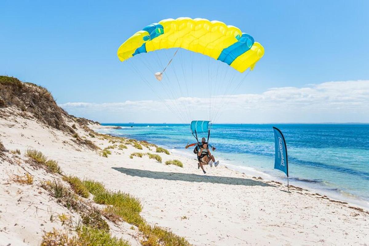 ein Mann, der am Strand mit einem Fallschirm fliegt