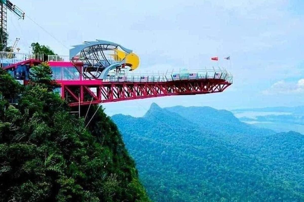 một cây cầu treo màu đỏ trên đỉnh núi