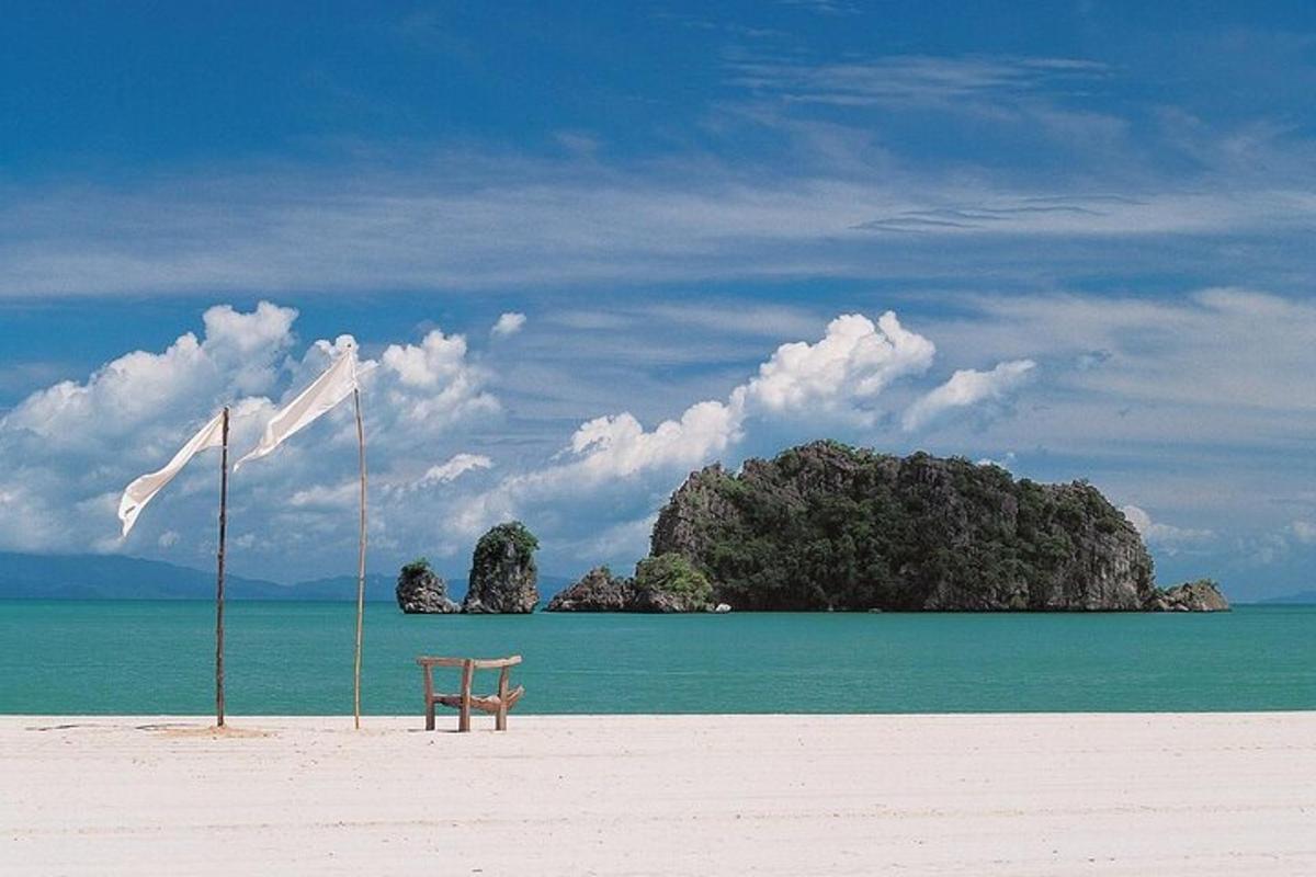 una sedia su una spiaggia con un'isola nell'acqua