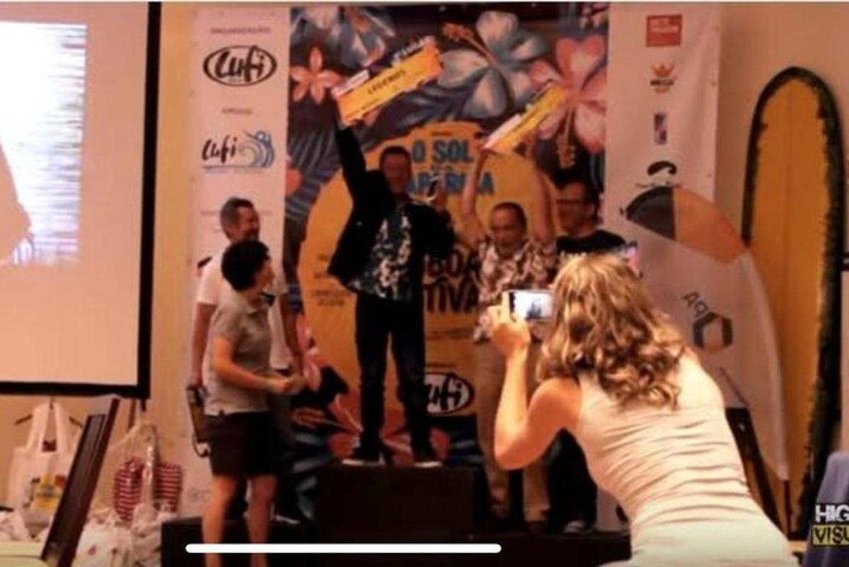 sieviete uz skatuves fotografē vīrieti