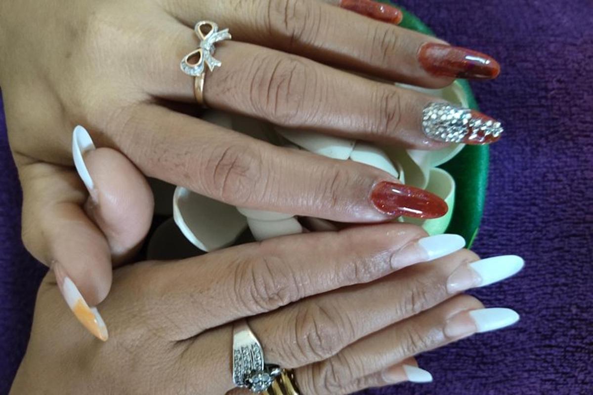 un paio di mani con le dita rosse che tengono una tazza
