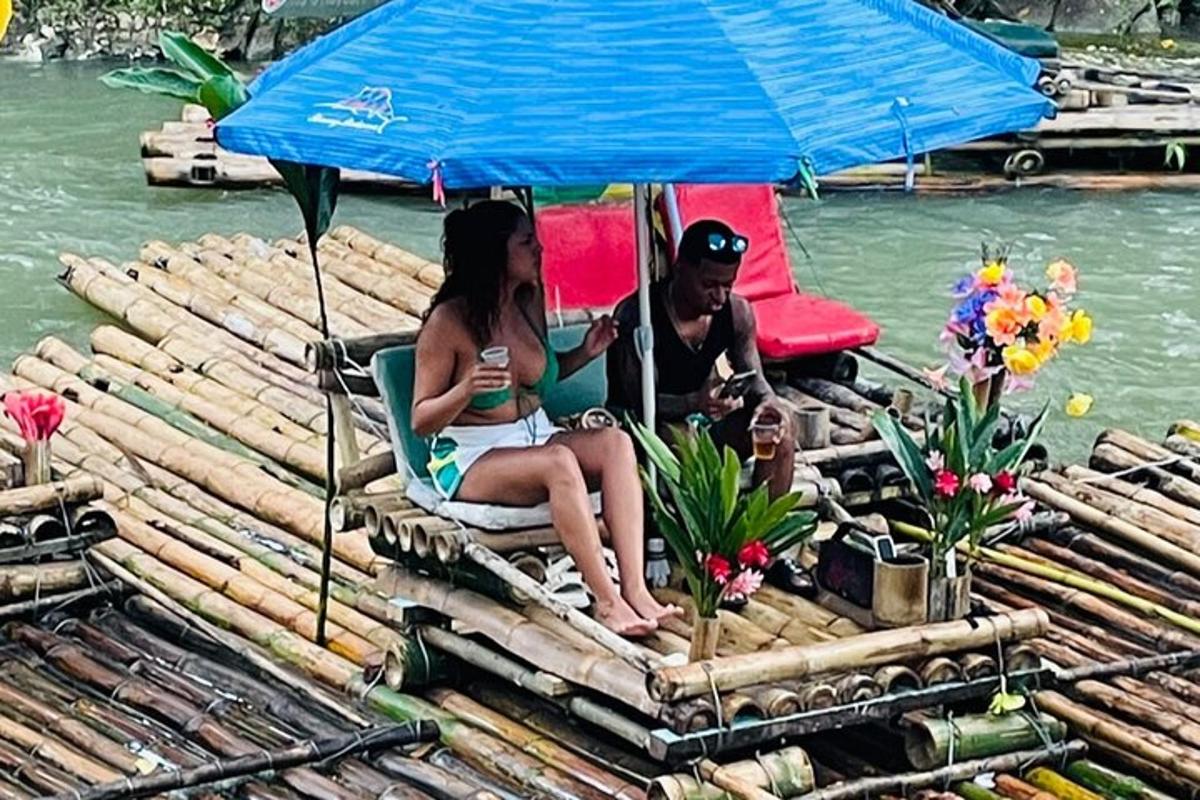 um homem e uma mulher sentados sob um guarda-chuva em uma jangada