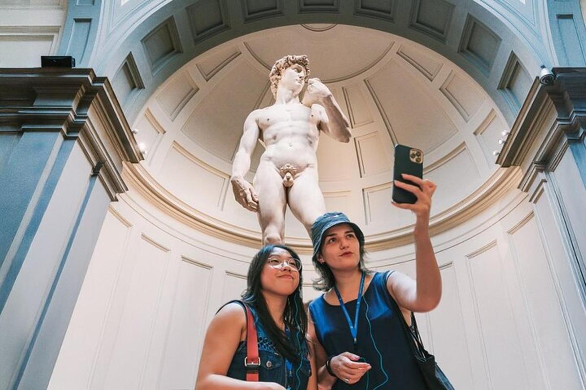 duas mulheres tirando uma foto em frente a uma estátua