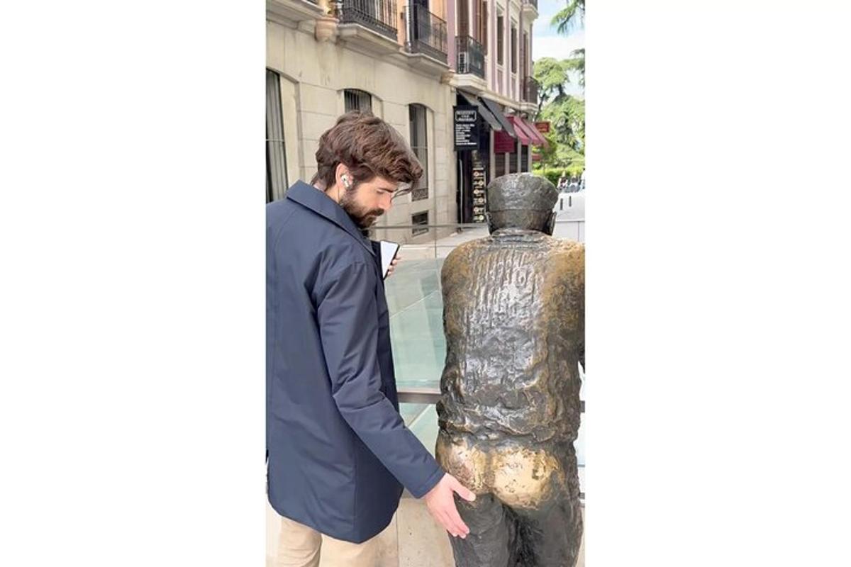 un hombre de pie junto a una estatua