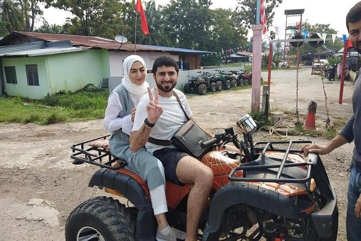 muž a žena sedící na motorce