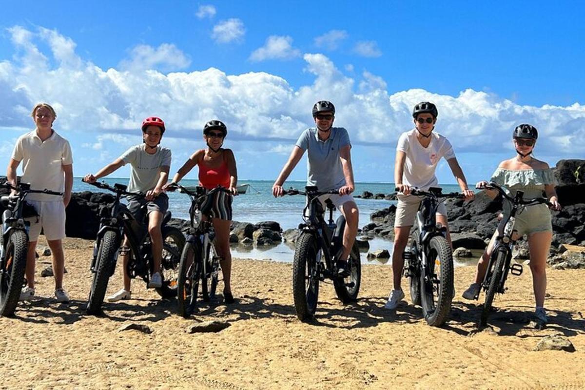 Un grupo de personas montando en bicicleta en la playa