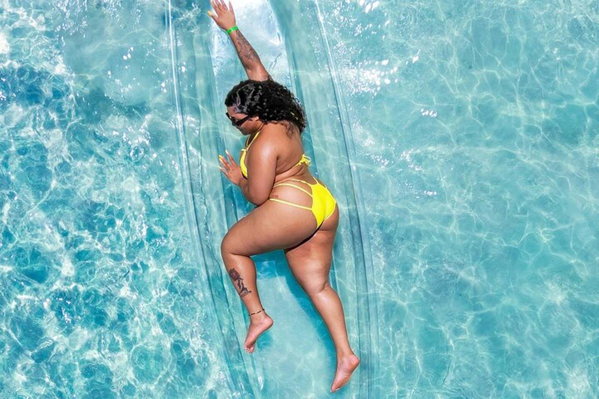 una donna in bikini giallo che cavalca un aogie board in una piscina