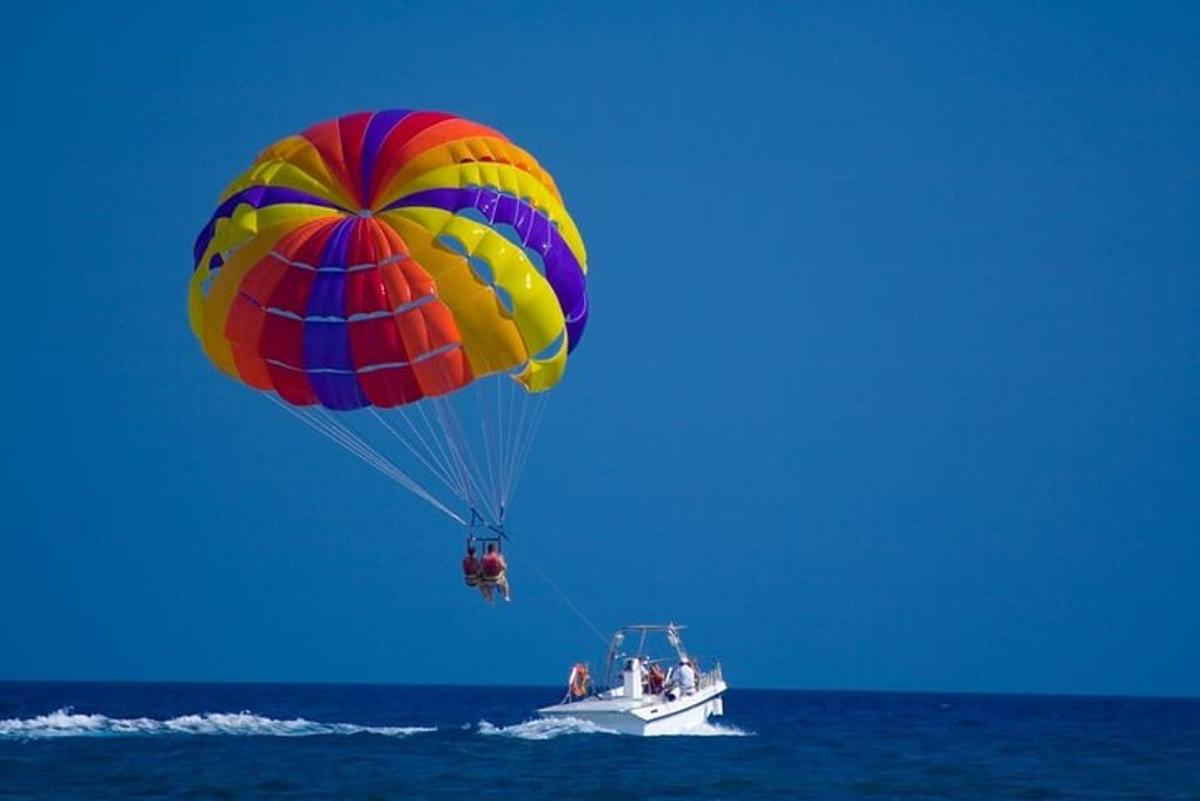 un paracadute colorato che vola sopra una barca nell'oceano