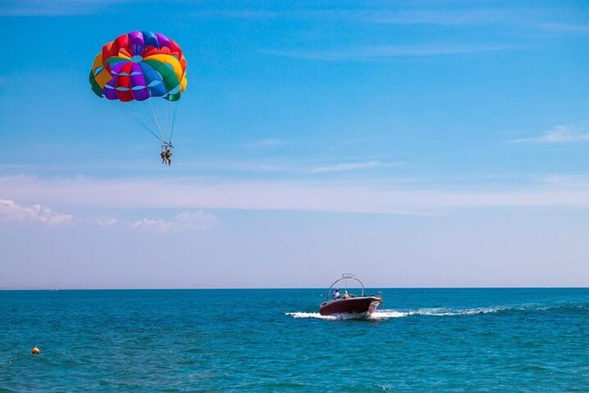 un paracadute colorato che vola sopra una barca nell'oceano