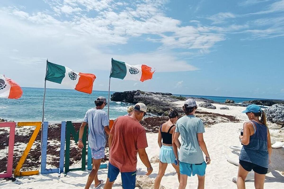 a group of people walking on a beach with flags