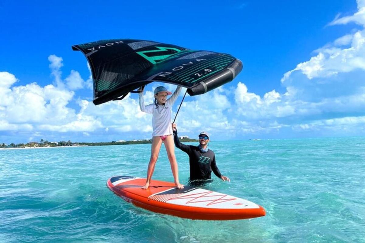 a man holding an umbrella on a surfboard in the ocean