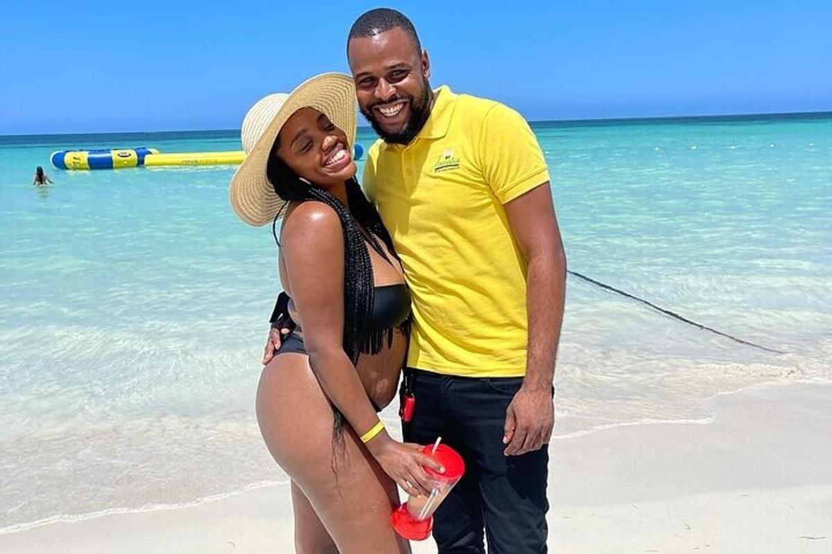 un uomo e una donna in piedi sulla spiaggia