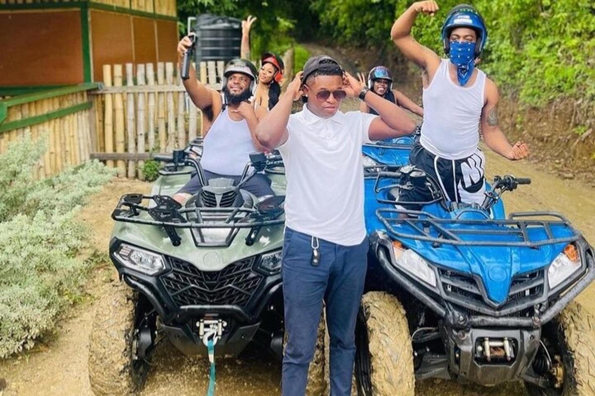 un gruppo di persone in piedi accanto a due quad