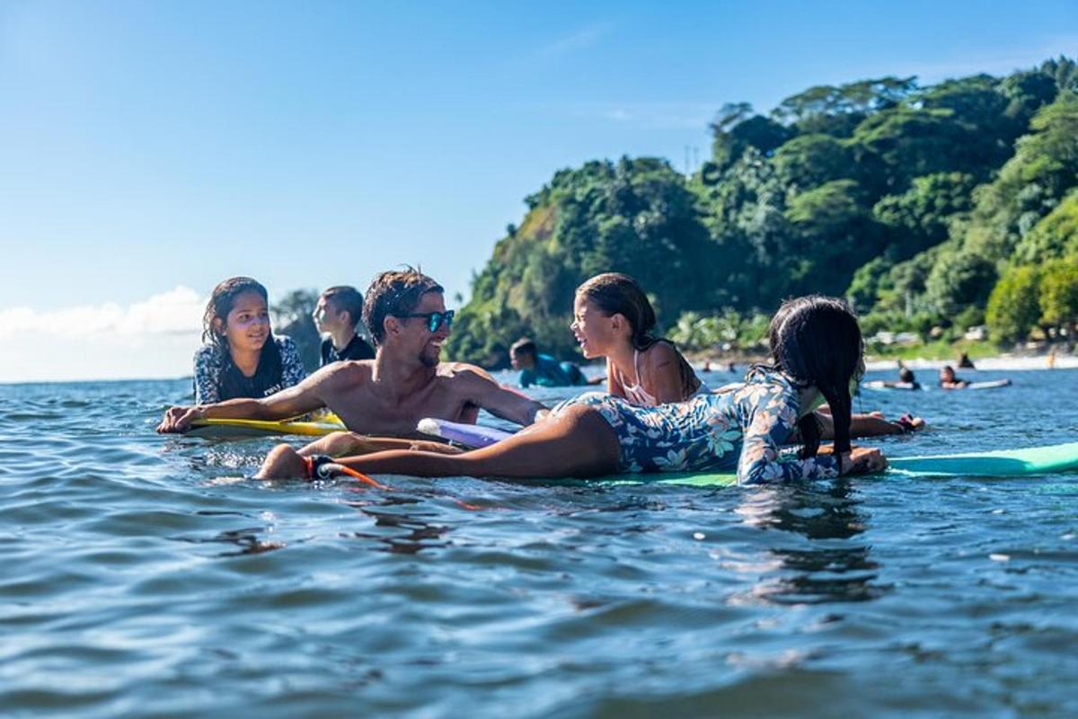 eine Gruppe von Menschen, die auf Surfbrettern im Wasser sitzen