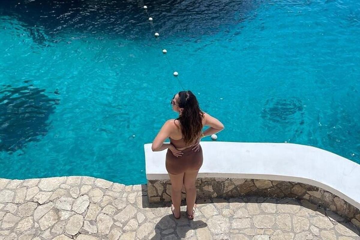 una donna in piedi davanti a una piscina d'acqua