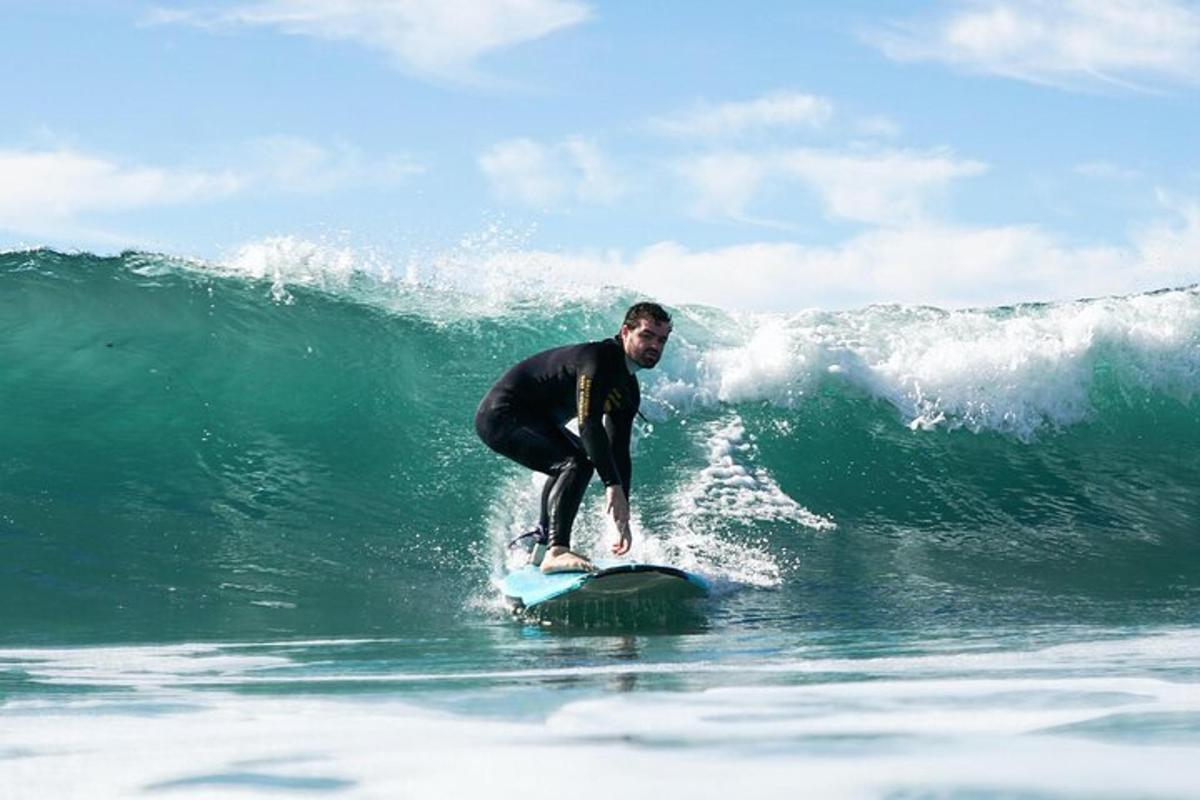 en mann som rir på en bølge på et surfebrett i havet
