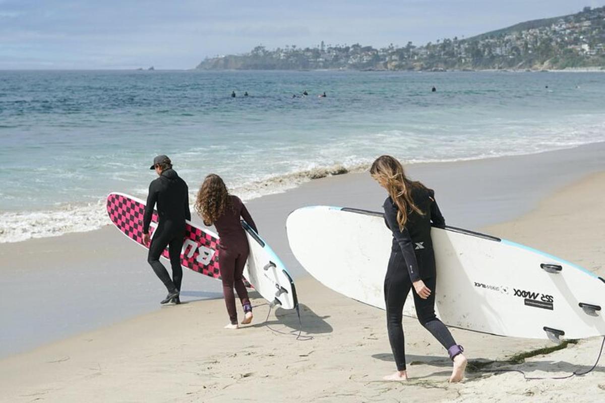 tre surfisti che camminano sulla spiaggia con le loro tavole da surf