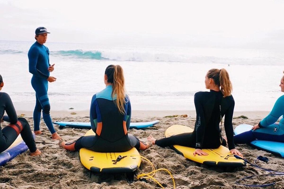 un gruppo di persone sedute su tavole da surf sulla spiaggia