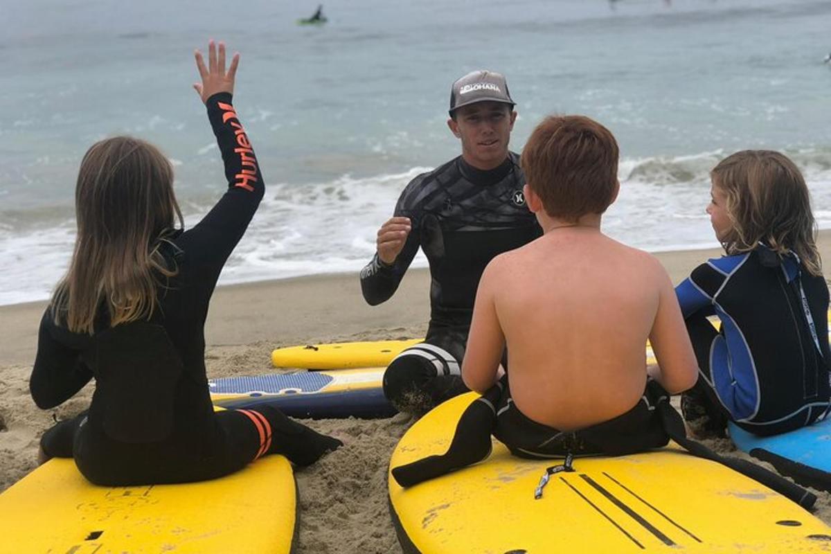 un gruppo di persone sedute su tavole da surf sulla spiaggia