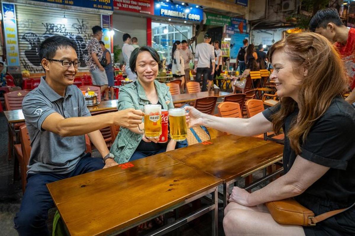 Un grupo de personas sentadas en una mesa bebiendo cerveza