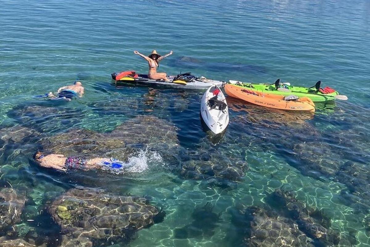un gruppo di persone in acqua accanto alle barche