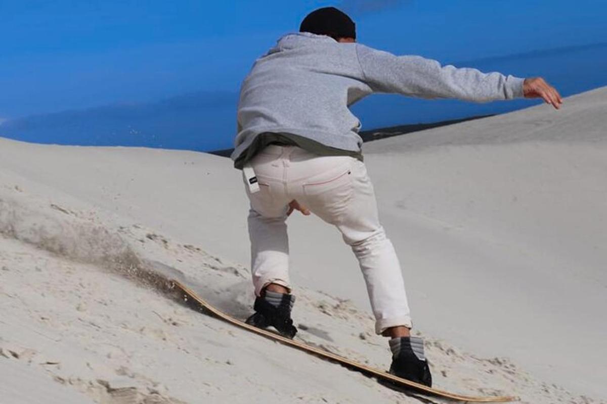 Ένας άντρας κάνει snowboard σε μια χιονισμένη πλαγιά