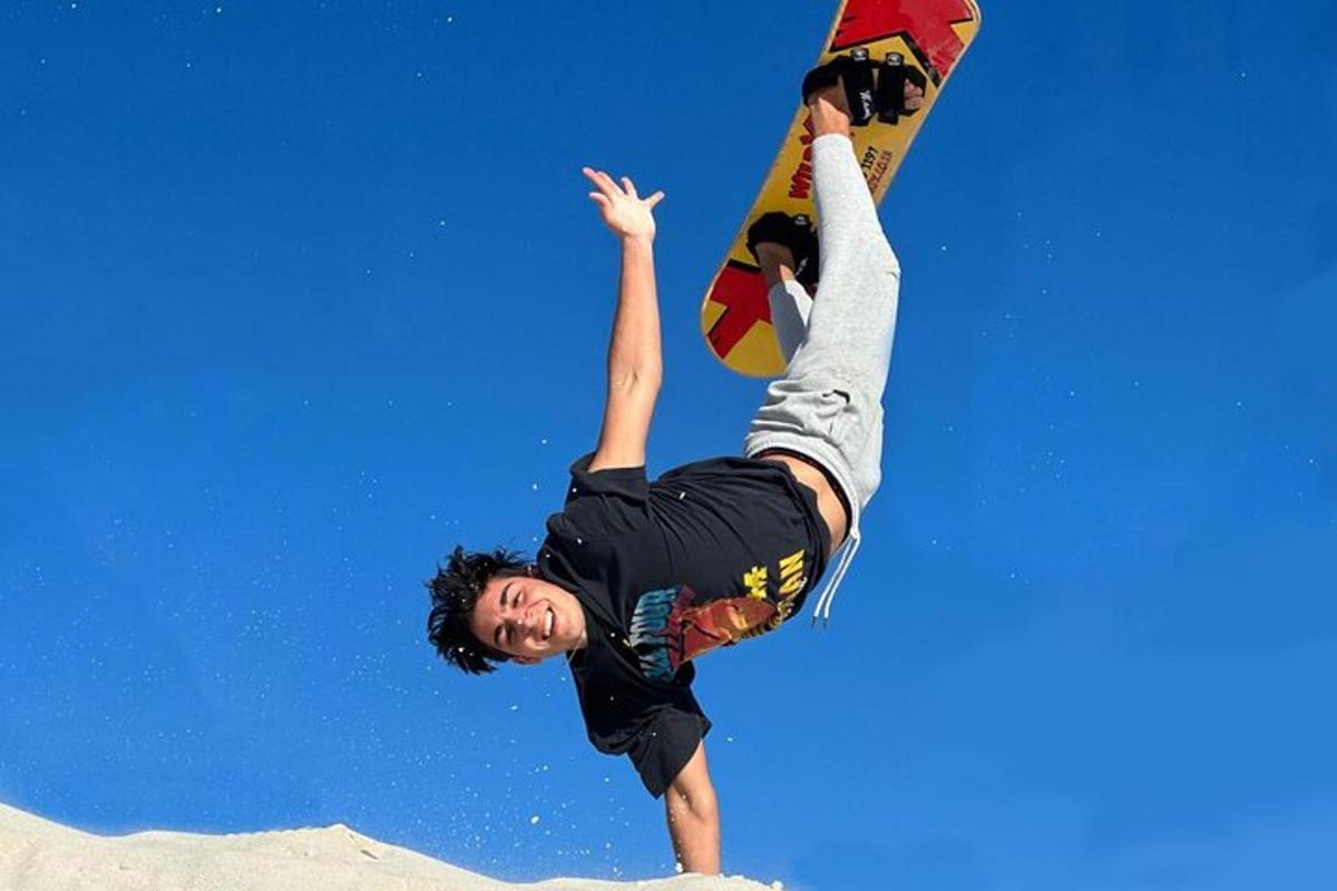 muž předvádí trik na snowboardu