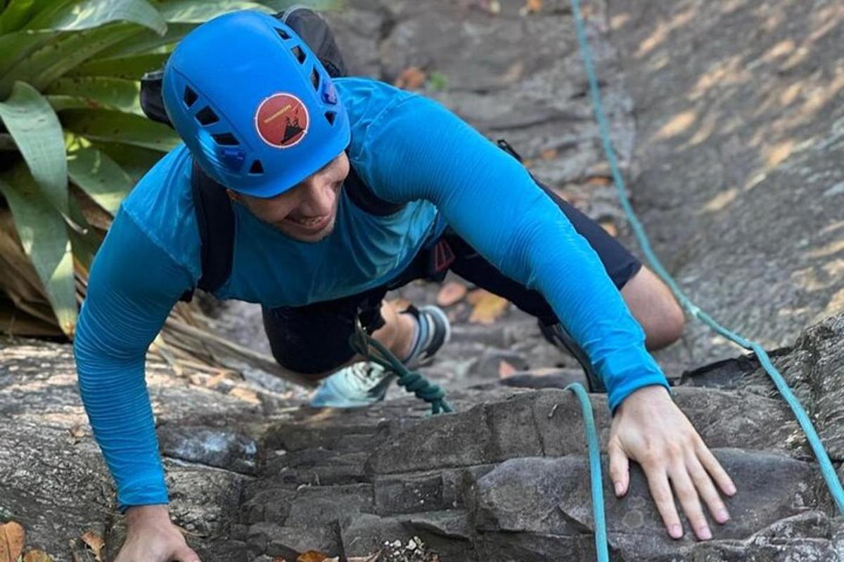 uma mulher de capacete escalando algumas rochas