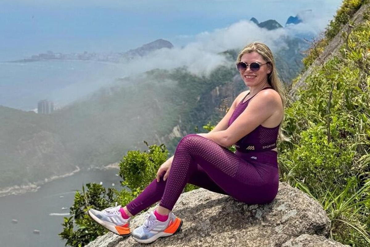 uma mulher sentada na beira de uma montanha