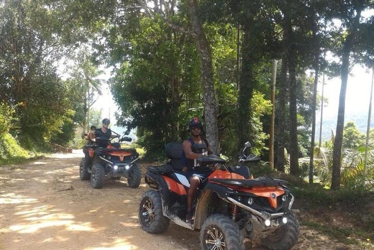 dua orang menunggang atv di jalan tanah