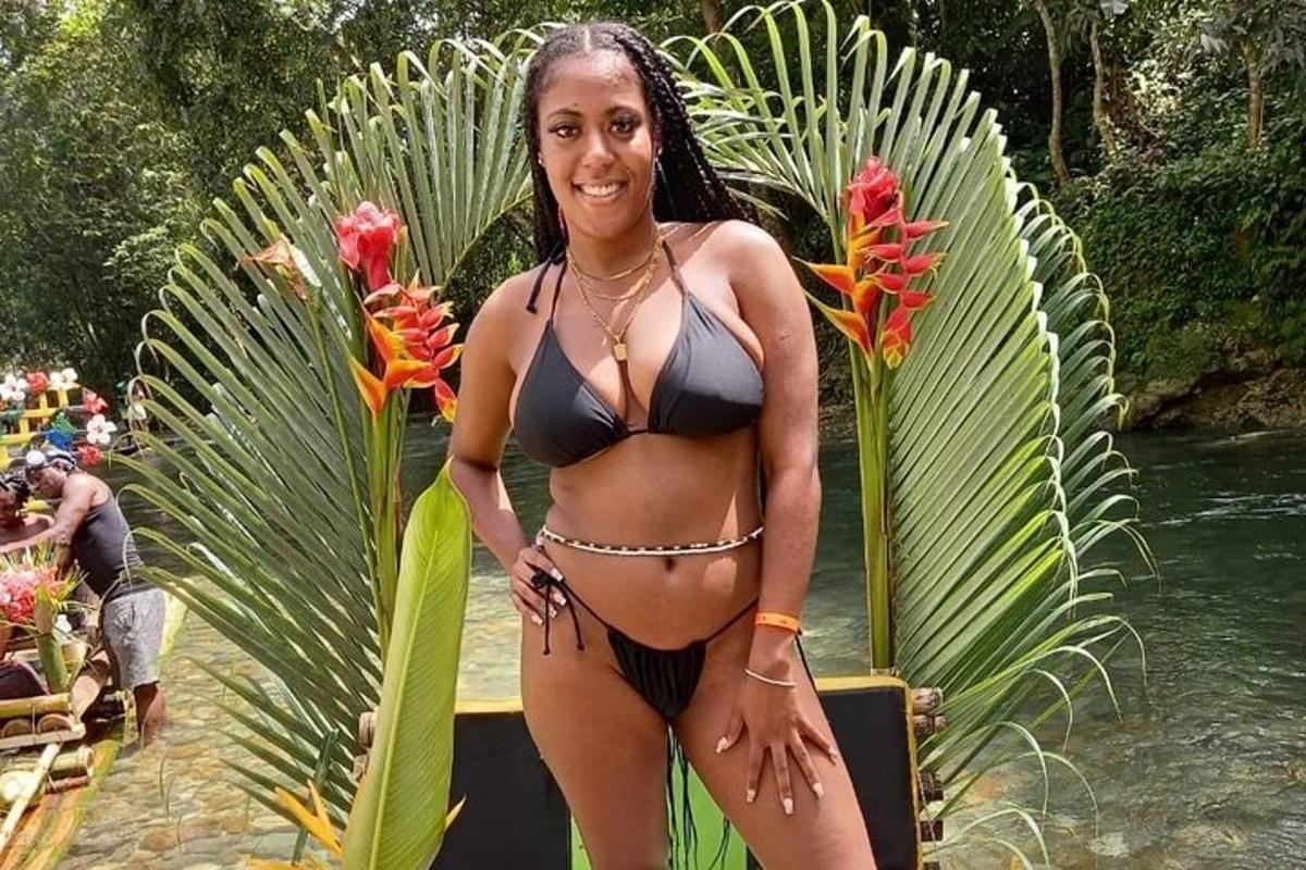 una donna in bikini in piedi accanto all'acqua
