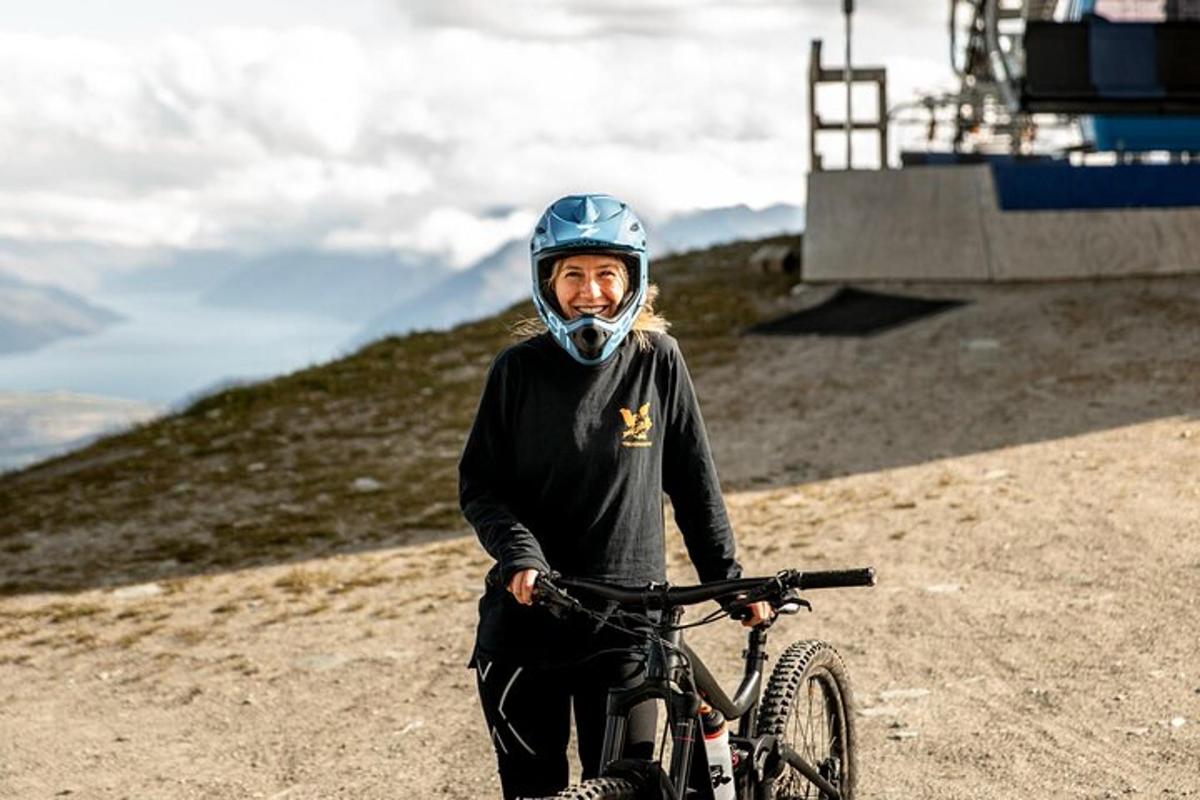 a woman standing next to a bike on a hill