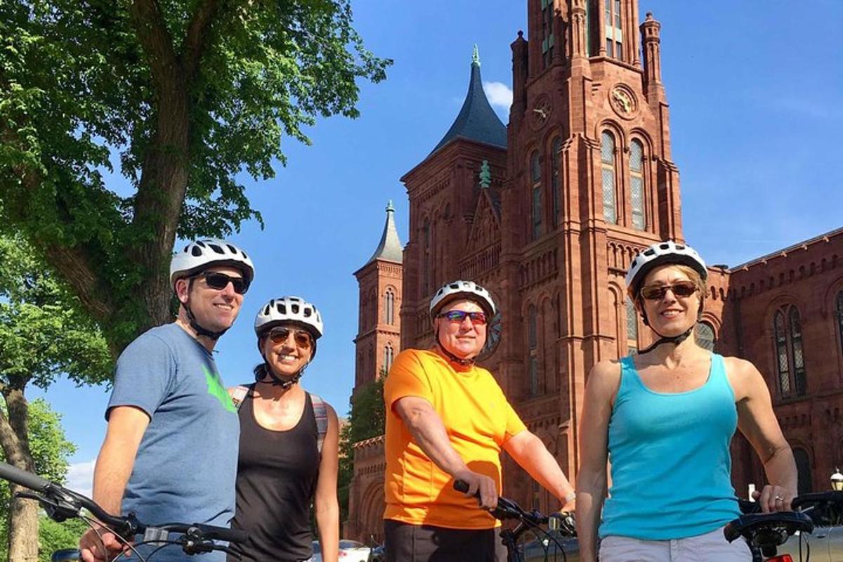 un grup de persones dretes davant d'un edifici amb les seves bicicletes