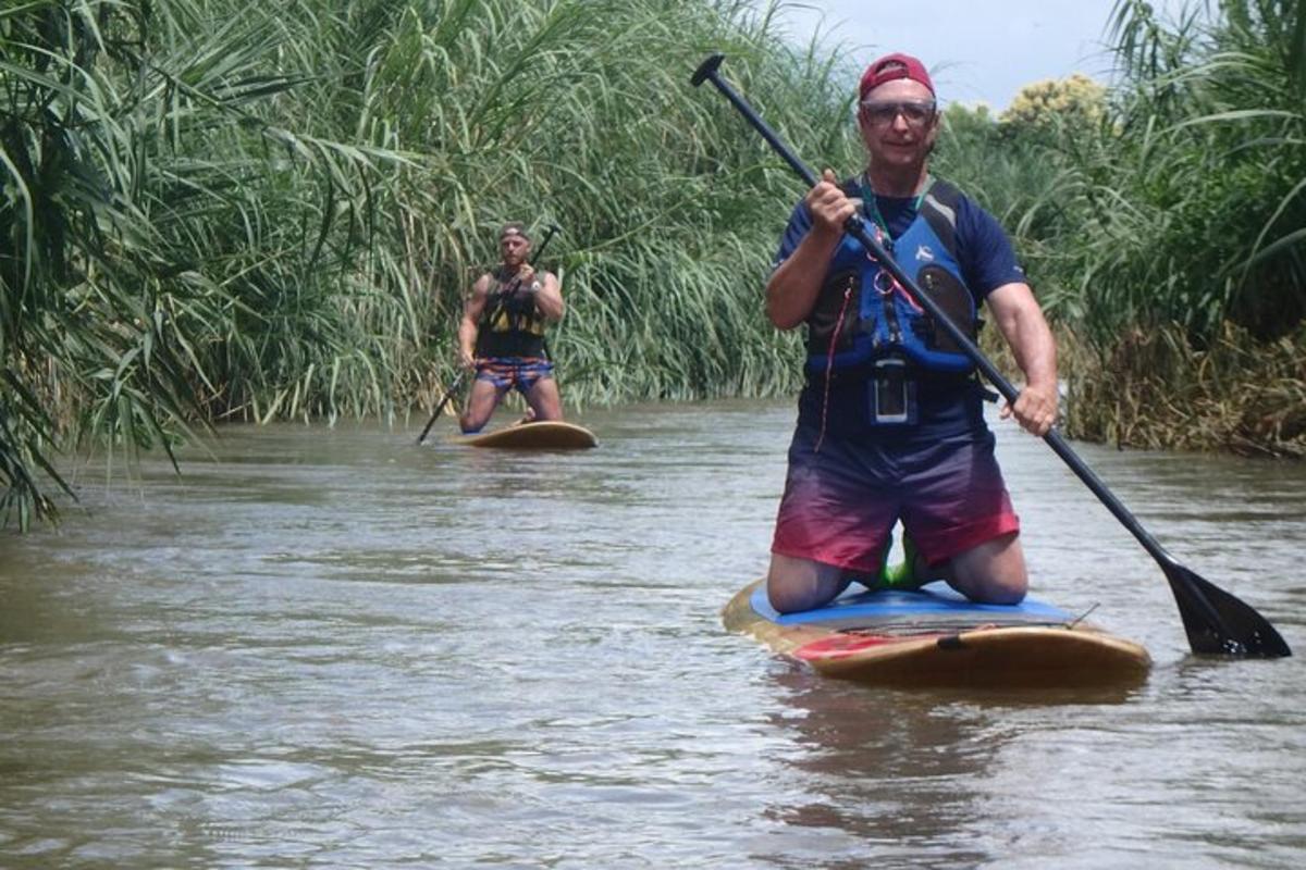 Dva moška veslata na deski na reki