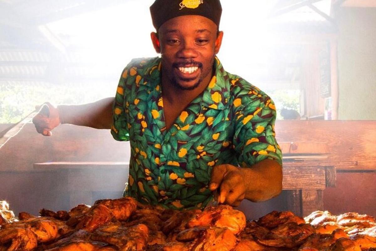 seorang lelaki berdiri di belakang rak ayam barbeku