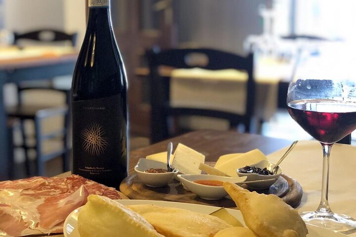 a bottle of wine and a plate of cheese and a glass
