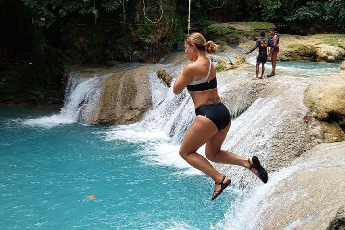seorang wanita berbikini melompat ke dalam air terjun