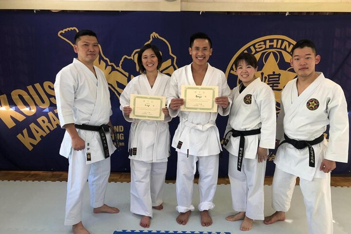 un grup de persones amb quimonos blancs sostenint certificats