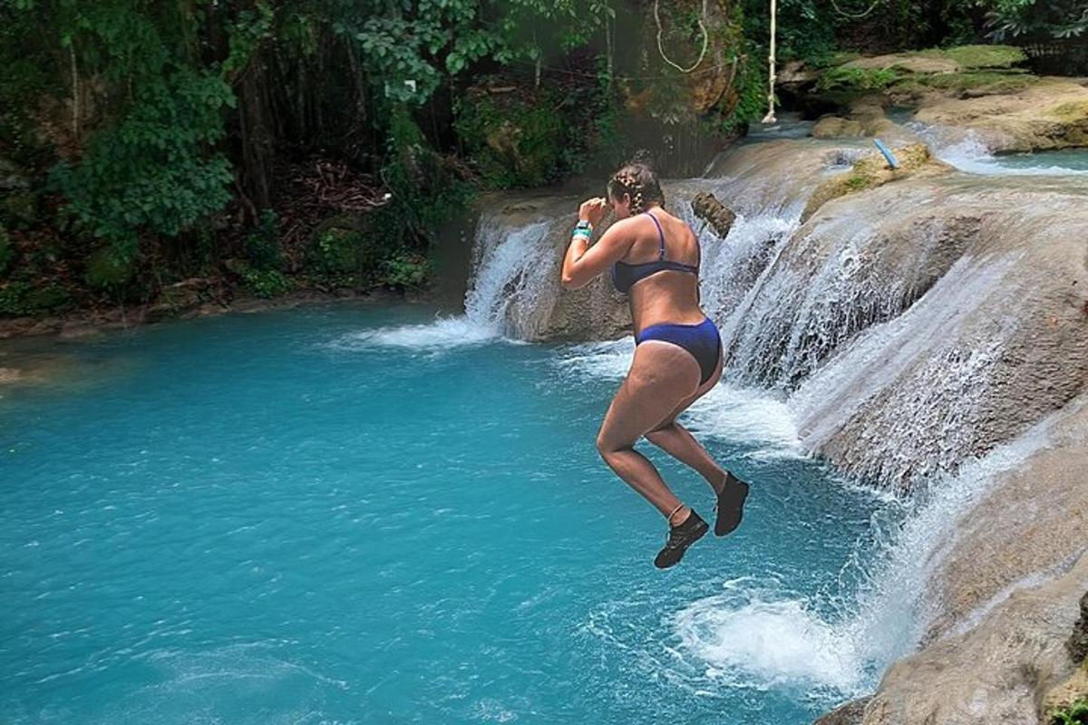 seorang wanita berbikini melompat ke dalam air terjun