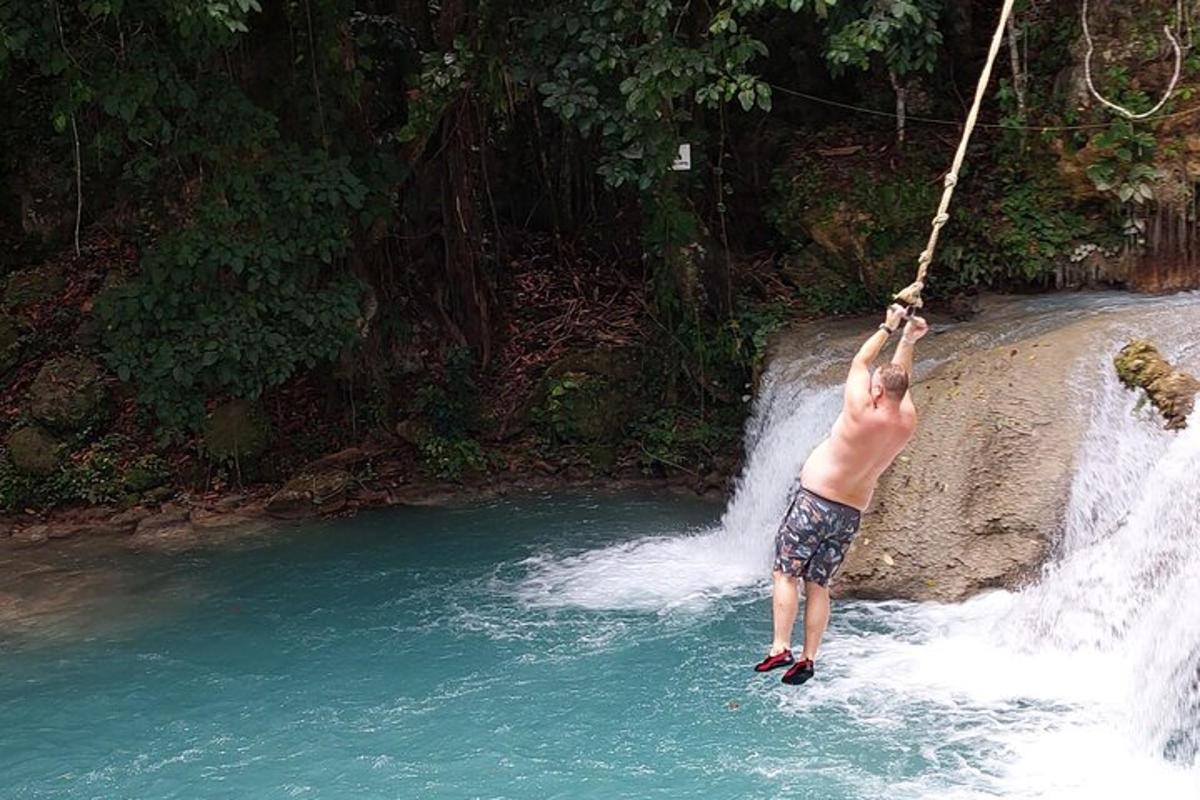 un uomo appeso a una corda sopra una cascata